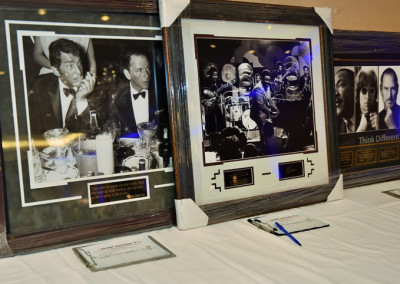 A display of framed photographs and posters on a table, including images of famous movie scenes and celebrity portraits.
