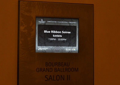 Digital display on a wall announcing the "blue ribbon soiree exhibits" event in the gourbeau ballroom, salon ii, from 7:00 pm to 10:00 pm.