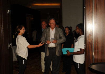 Attendees interacting with staff at a conference entrance.