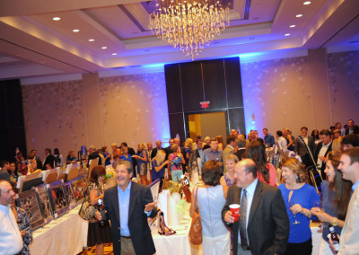 Guests mingling in a hotel ballroom with a chandelier during a formal event.