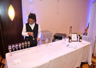 A man pouring wine at a table at an event.