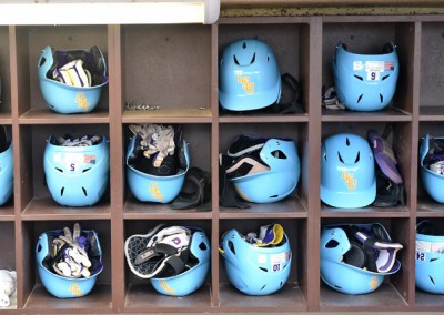 A locker full of blue baseball helmets.