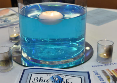 A blue bowl with a candle in it.