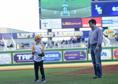 A man and a boy standing on a baseball field.